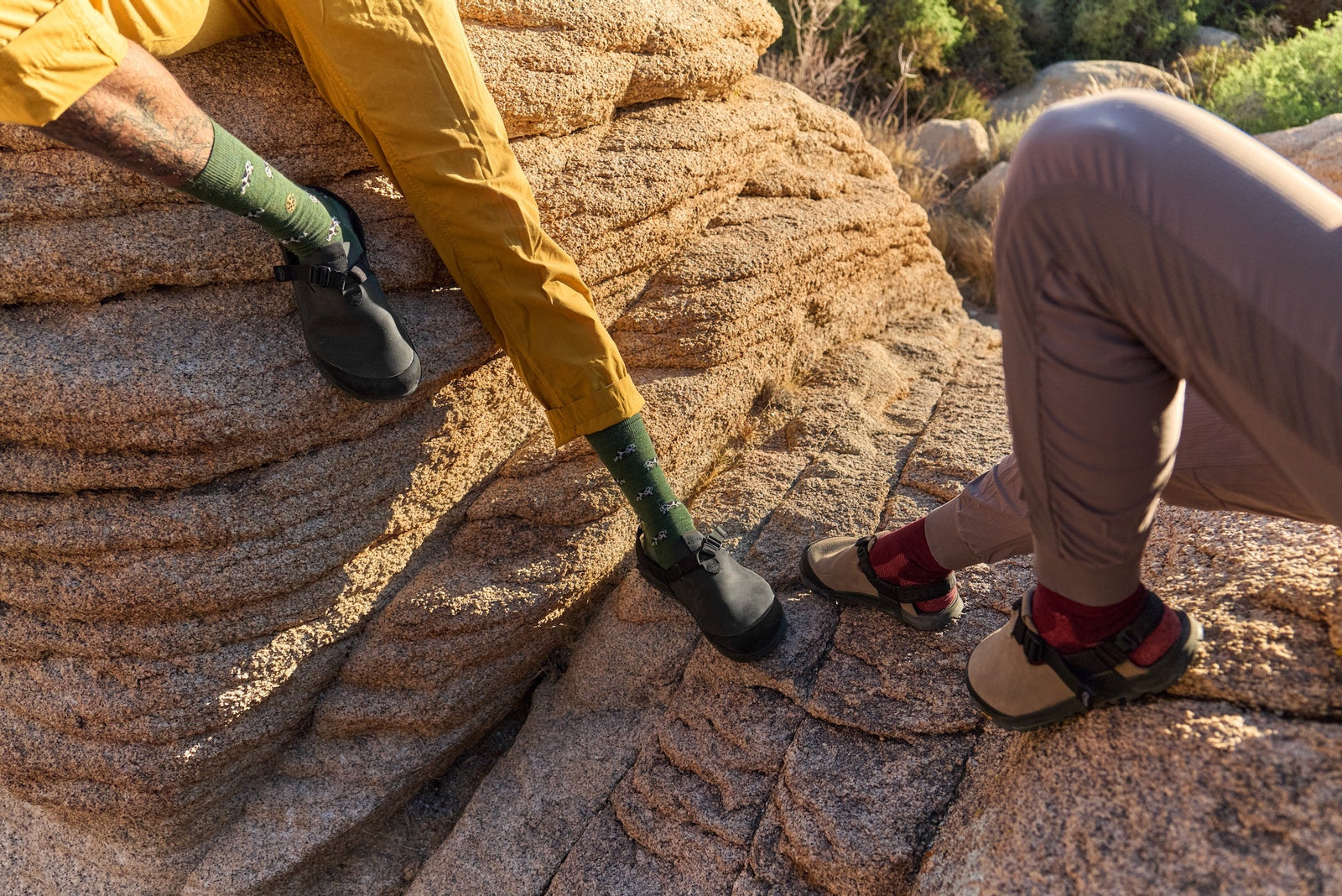 Two people wearing different styles of Mountain Clogs in the desert
