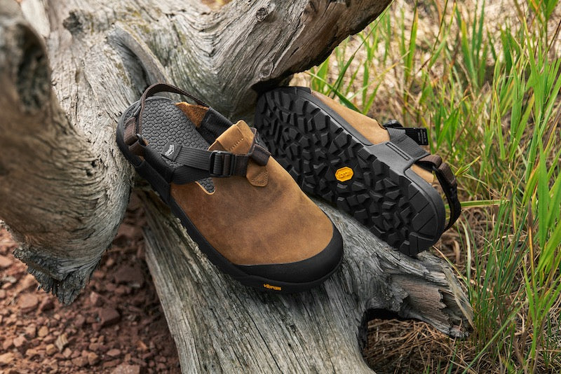 brown nubuck leather mountain clogs displayed on a log