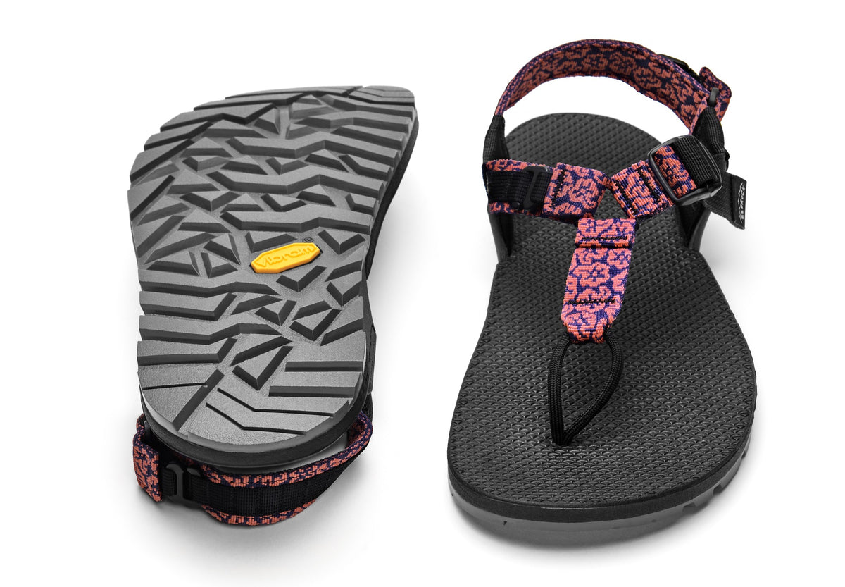 A pair of Cairn Evo PRO Sandals with pink wildflower patterned straps and black footbed, featuring a hook-and-loop strap design and Vibram Megarip outsole.