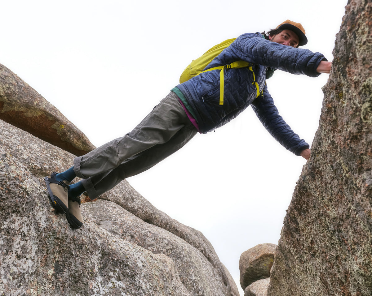 A person balancing in between rocks wearing Driftwood gray Nubuck leather Mountain Clogs