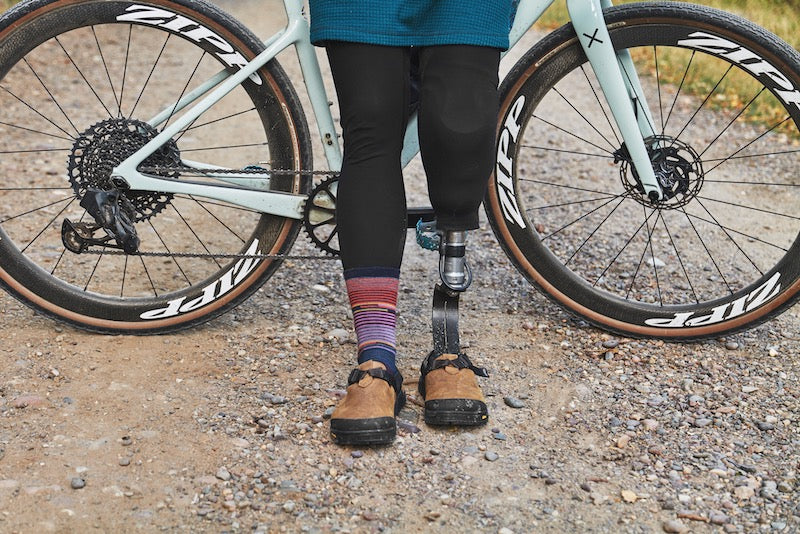 person with a bike in background wearing brown nubuck leather mountain clogs