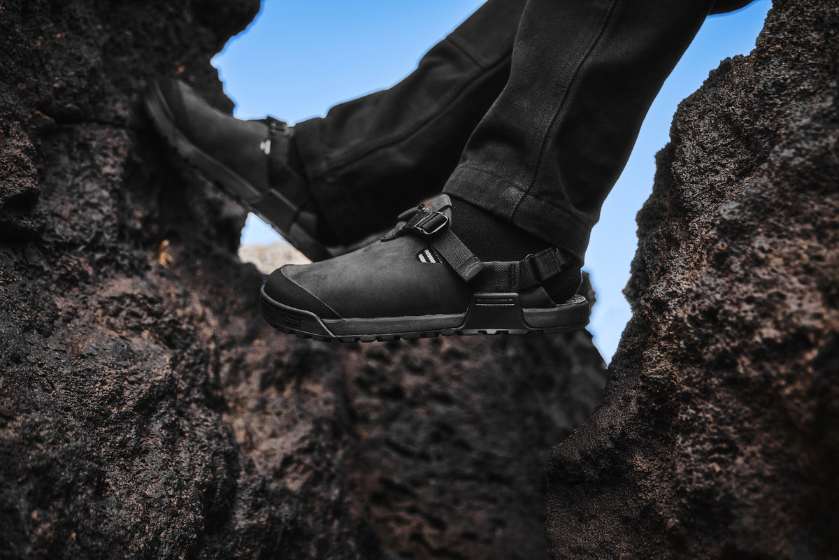 Obsidian Dark Gray Mountain Clogs pictured on volcanic black rock