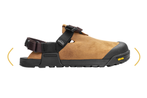 A tan and black Vibram work sandal shown from the side against a white background, with yellow curved arrows indicating a wide toe box.
