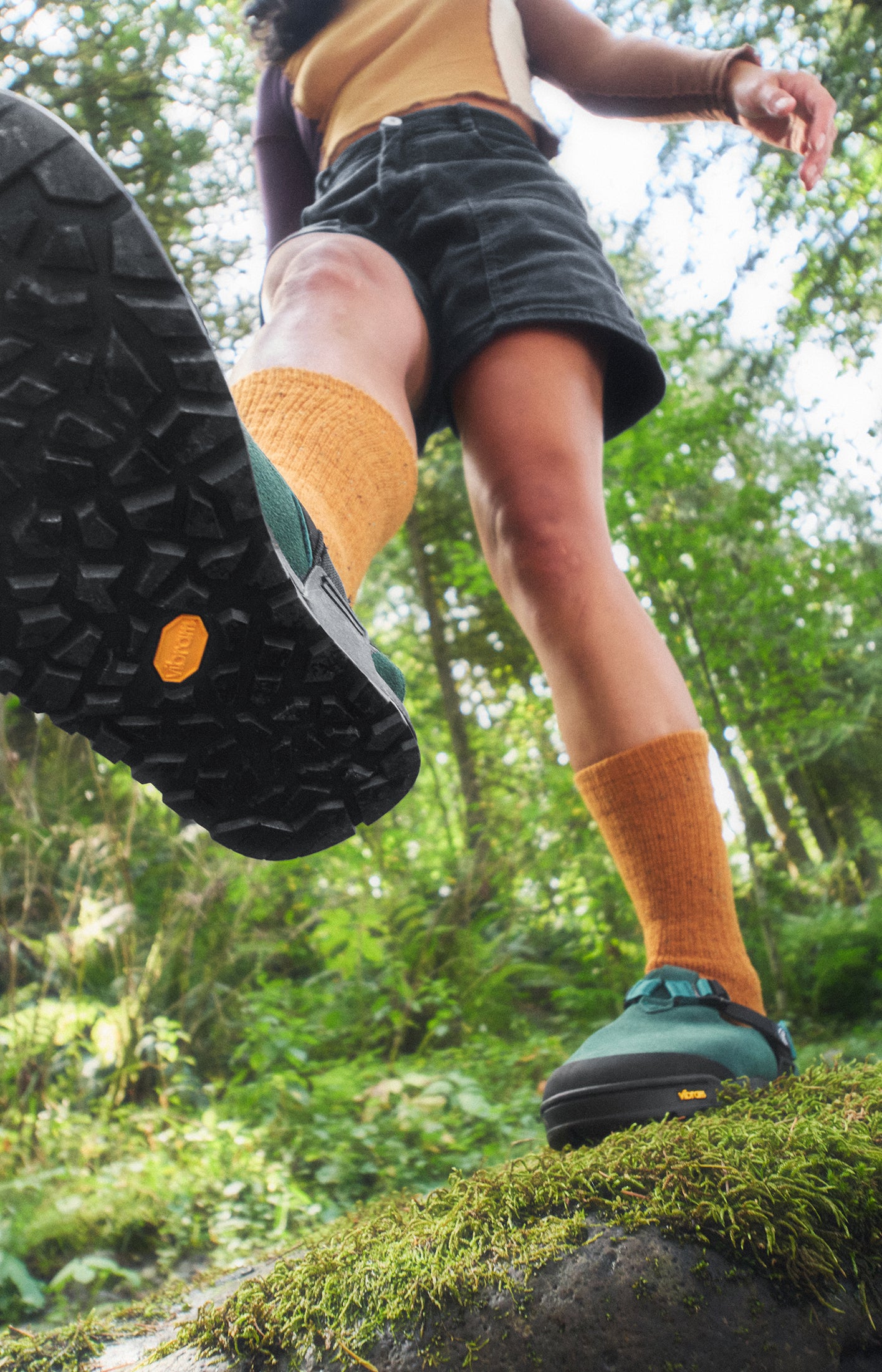 Green mountain clog with person balancing