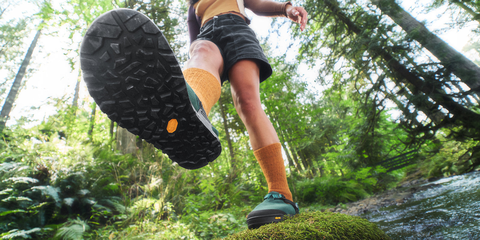 Green mountain clog with person balancing
