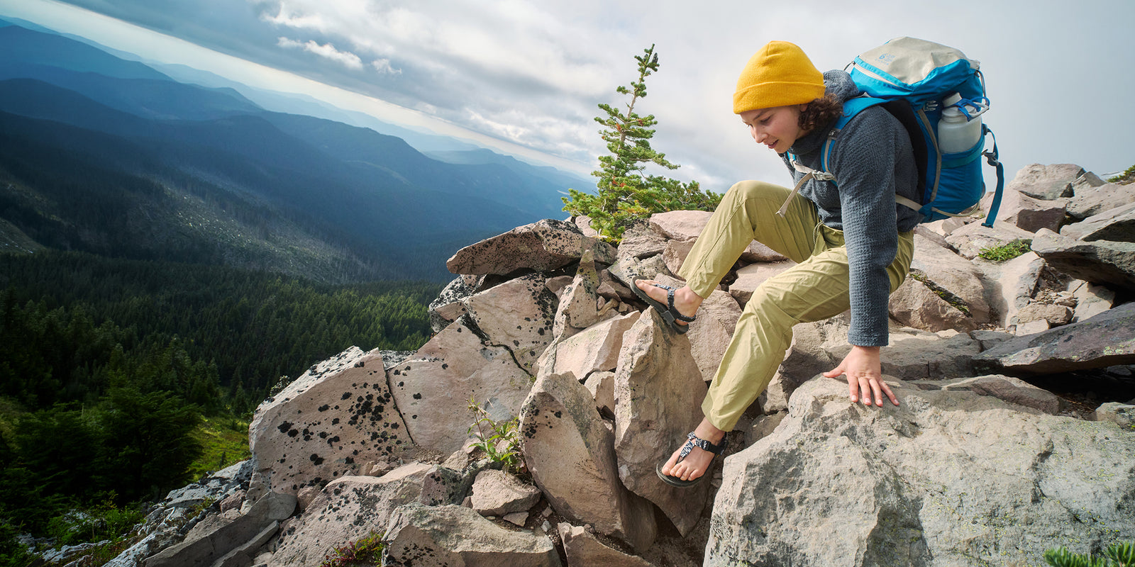 Hiker scrambles over alpine terrain in Cairn sandals